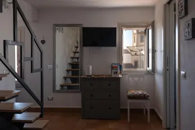 a room with a dresser and a window and a staircase at Sopra i tetti di Ballarò in Palermo