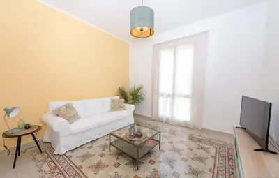 a living room with a white couch and a tv at Casa Martini Mondello in Palermo