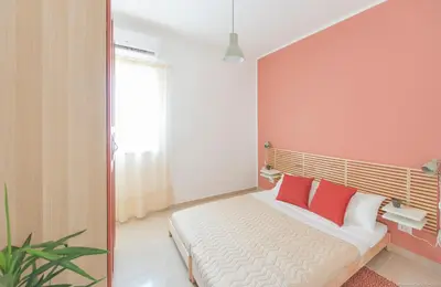a bedroom with a bed with two red pillows at Casa Martini Mondello in Palermo