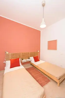 two beds in a room with orange walls at Casa Martini Mondello in Palermo