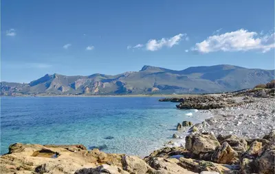 a rocky beach with mountains in the background at Lovely Home In Makari-S Vito Lo Capo in Macari