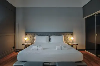 a bedroom with a large white bed with two tables at Palco Noir! in Palermo