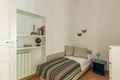 a bedroom with a bed with a striped blanket on it at Una Finestra sul Teatro Massimo by Wonderful Italy in Palermo