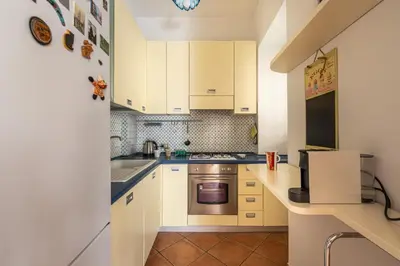 a small kitchen with white cabinets and a sink at Una Finestra sul Teatro Massimo by Wonderful Italy in Palermo