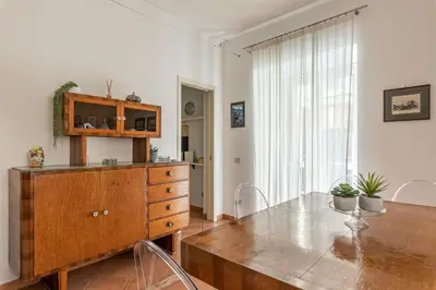 a dining room with a table and a wooden dresser at Una Finestra sul Teatro Massimo by Wonderful Italy in Palermo
