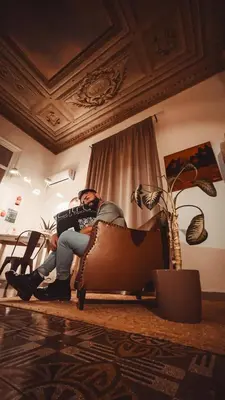a man sitting in a chair in a room at CITRUS LUXURY APARTMENT - holiday apartment with up to 3 bedrooms in palermo center in Palermo