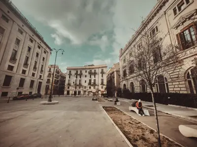 a person sitting on a bench in the middle of a street at CITRUS LUXURY APARTMENT - holiday apartment with up to 3 bedrooms in palermo center in Palermo