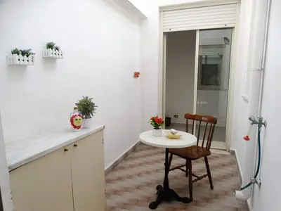 a small white kitchen with a table and a chair at Holiday Home Sferracavallo in Palermo