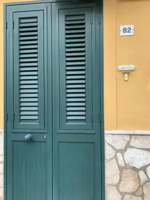 a green door of a building with the number at Holiday Home Sferracavallo in Palermo