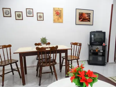 a dining room with a table and chairs and a tv at Holiday Home Sferracavallo in Palermo
