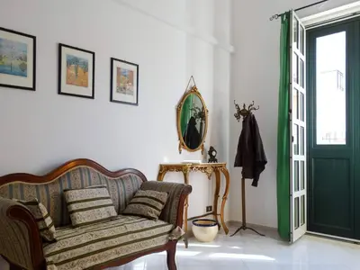 a living room with a couch and a green door at Holiday Home Sferracavallo in Palermo