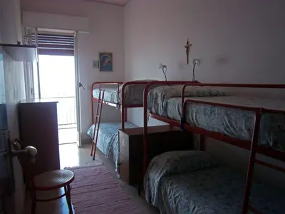 a room with three bunk beds and a chair at Terrazza sul mare in Trabia