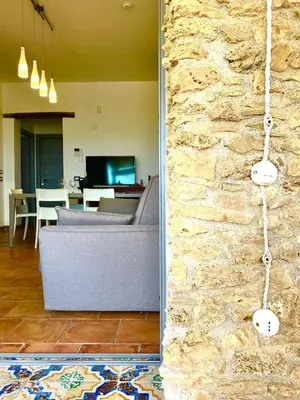 a living room with a stone wall and a couch at Giardini Del Golfo in Balestrate