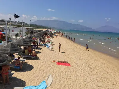a crowd of people on a beach with umbrellas at Giardini Del Golfo in Balestrate