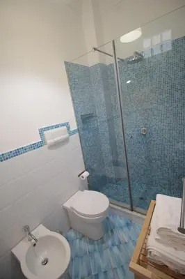 a bathroom with a toilet and a glass shower at Federico Secondo in Palermo