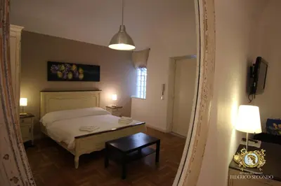 a bedroom with a bed and a table and a lamp at Federico Secondo in Palermo