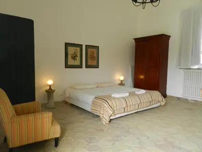 a bedroom with a bed and a chair at Masseria Acque Di Palermo in Roccapalumba
