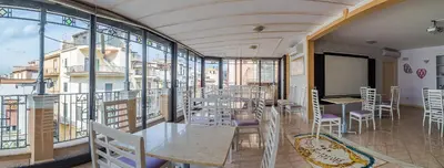 a restaurant with tables and chairs on a balcony at Hotel Centrale Bagheria in Bagheria