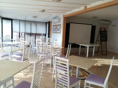 a classroom with tables and chairs and a chalkboard at Hotel Centrale Bagheria in Bagheria