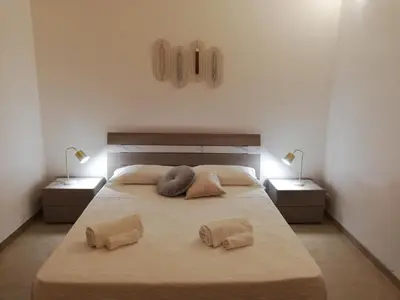 a bedroom with a large bed with two lamps at Il Volo Dei Gabbiani in Scopello