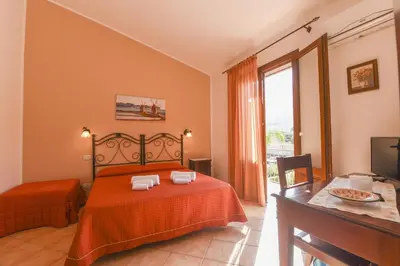 a bedroom with a bed and a table and a window at Aurora Castelluzzo in Castelluzzo