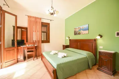 a bedroom with a bed and a desk with a computer at Aurora Castelluzzo in Castelluzzo