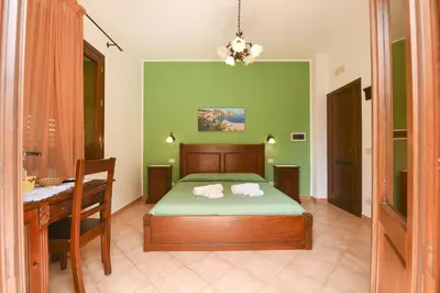 a bedroom with a bed and a table and a desk at Aurora Castelluzzo in Castelluzzo