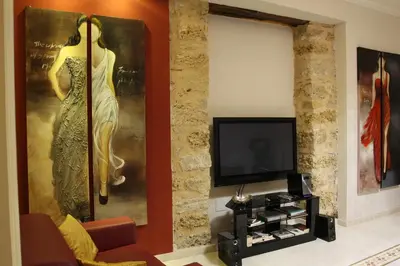 a living room with a television and a painting of a woman at Abatellis Luxury in Palermo