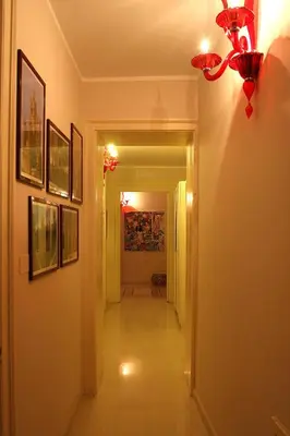 a hallway with a chandelier and pictures on the walls at Abatellis Luxury in Palermo