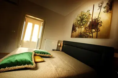 a bedroom with a bed with two green pillows at Abatellis Luxury in Palermo