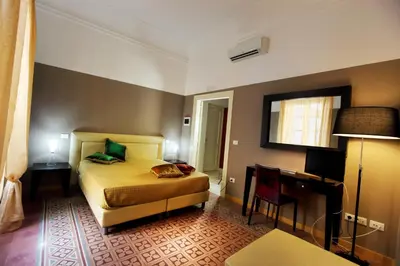 a hotel room with a bed and a desk and a room at Abatellis Luxury in Palermo