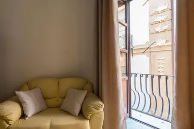 a yellow couch sitting in front of a window at B&B Addauru in Palermo