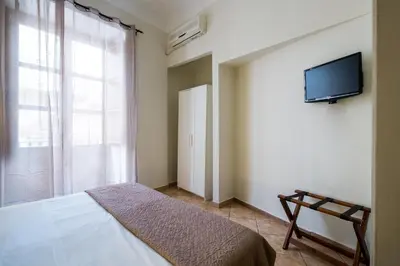 a bedroom with a bed and a television on a wall at B&B Addauru in Palermo