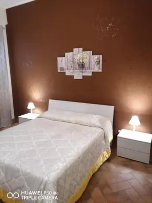 a bedroom with a white bed and two night stands at Paradise in Palermo