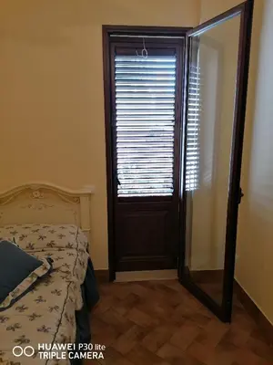 a bedroom with a bed and a door with a mirror at Paradise in Palermo