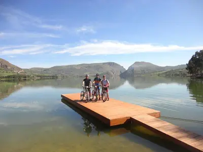 two people riding bikes on a dock in a lake at Casa Vacanze Caccamo Santa Lucia in Caccamo