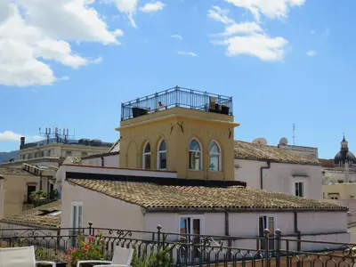 a yellow building with a balcony on top of it at Sunny loft with terrace and Jacuzzi in the city centre in Palermo
