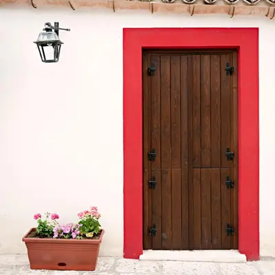 a door with a red frame and a pot of flowers at Agriturismo Sirignano Wine Resort in Sirignano