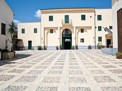 a large white building with a courtyard at Agriturismo Sirignano Wine Resort in Sirignano