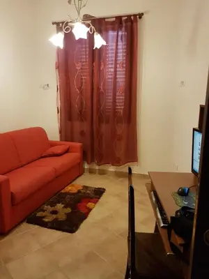 a living room with a red couch and a table at VILLA BUTTERFLY 1 sea and history in Capaci