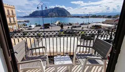 two chairs on a balcony with a view of a harbor at Mondello Vista Mare in Mondello