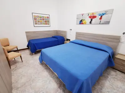 a hotel room with two beds and a chair at Mondello Vista Mare in Mondello