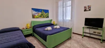 a bedroom with a green bed and a flat screen tv at Mondello Vista Mare in Mondello
