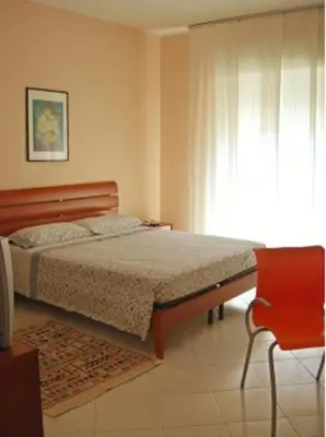 a bedroom with a bed and a chair and a window at Costapicca in Alcamo
