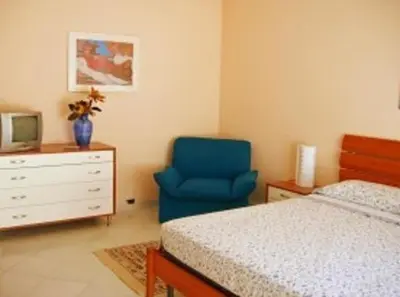a bedroom with a bed and a blue chair at Costapicca in Alcamo