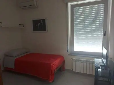 a bedroom with a red bed and a window at Costapicca in Alcamo