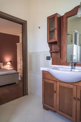 a bathroom with a sink and a mirror and a bed at Piano del Re rooms in Partinico