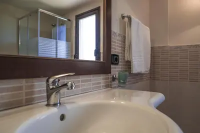 a bathroom with a white sink and a mirror at Piano del Re rooms in Partinico