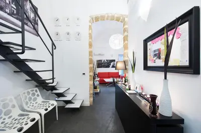 a living room with a staircase and a table and chairs at White in Palermo