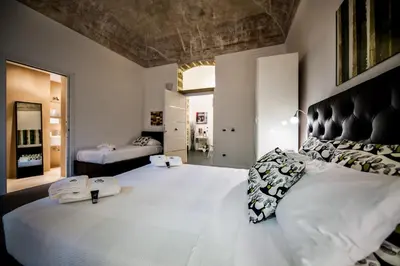 a large bedroom with a large white bed with pillows at White in Palermo